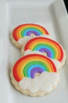 rainbow cookies with white icing on a plate