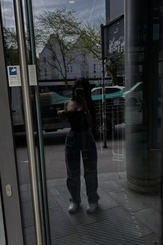 a woman standing in front of a glass door