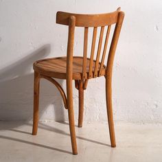 a wooden chair against a white wall