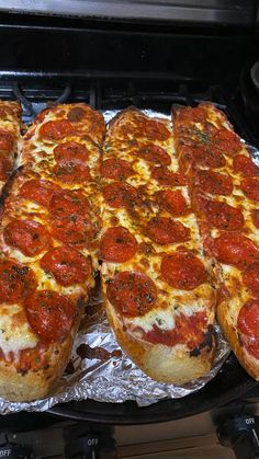 several slices of pepperoni pizza sitting on top of tin foil in an open oven