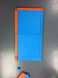 an orange and blue lego block sitting on top of a table next to a pair of scissors