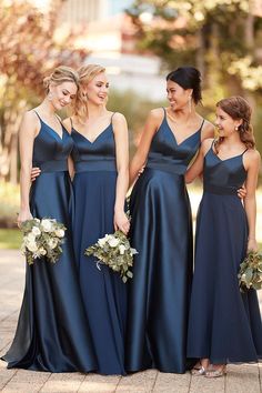 the bridesmaids are laughing together in their navy blue gowns and bouquets