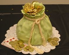 a green bag filled with gold coins sitting on top of a doily