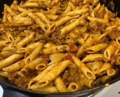 a skillet filled with pasta and meat sauce