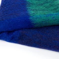 a blue and green blanket laying on top of each other