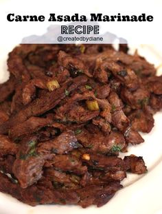 a white plate topped with cooked meat on top of a table