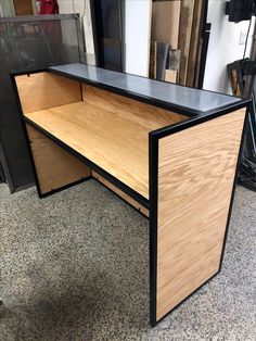 an office desk made out of plywood and black metal, with its doors open