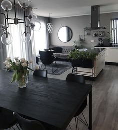 a dining room table with chairs and flowers in a vase on top of the table