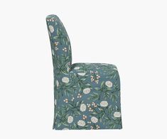 an upholstered chair with flowers and leaves on it