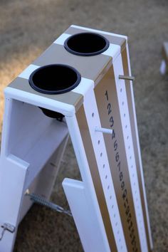 a cardboard box with two speakers attached to it sitting on the ground in front of some grass