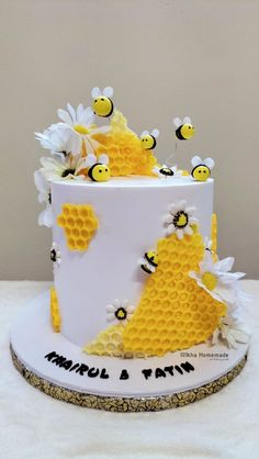 a white and yellow cake with bees on it