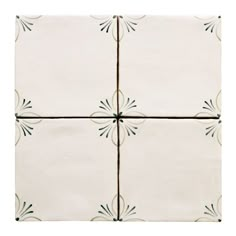 four white tiles with green designs on them