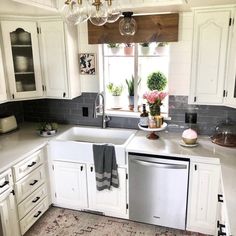 a kitchen with white cabinets and an area rug on the floor in front of the sink