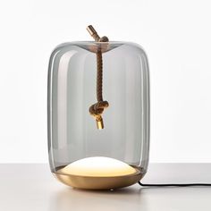 an apple shaped lamp with a rope attached to the top and bottom, sitting on a table