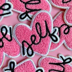 pink and black heart shaped cookies with the word hello spelled on them in cursive writing