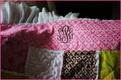 the monogrammed initials are on the pink and white quilted blanket that is made from different fabrics