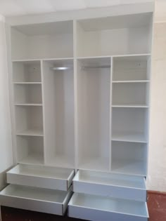 an empty white closet with shelves and drawers