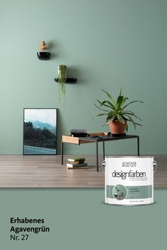 a green wall with a white paint can and some books on the table next to it