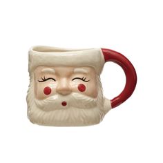 a ceramic mug with a santa claus face on it's side and red handles