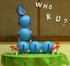 a table with balloons and decorations on it in front of a sign that says who's up?