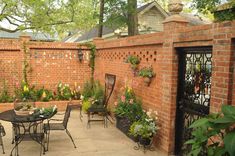 an outdoor patio with tables, chairs and potted plants on the side of it