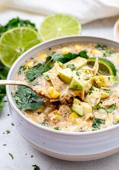 a white bowl filled with chicken tortilla soup and garnished with avocado