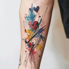 colorful ink splattered tattoo on the leg with hearts and swirls around it