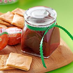 a wooden cutting board topped with crackers and jam