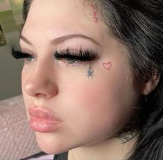 a close up of a person with tattoos on her face and eyebrows, looking at the camera