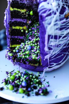 there is a cake with purple icing and green sprinkles on it