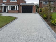 a driveway with gravel and grass around it