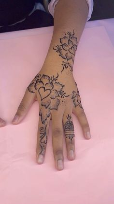 a woman's hand with hennap on it and flowers painted on the palm