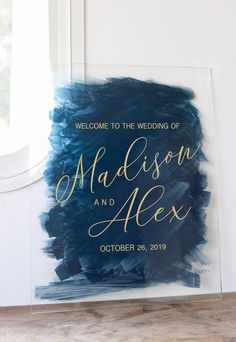 an acrylic sign with the words, welcome to the wedding of madison and alex