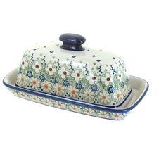 a ceramic covered dish with blue trim and flowers on the front, sitting on a white surface