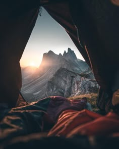 the view from inside a tent looking at mountains and valleys in the distance with sunlight coming through