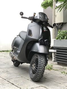 a motor scooter parked on the sidewalk next to a building