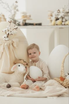 a little boy sitting next to an easter egg