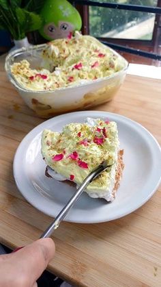 a person is cutting into a cake on a white plate with a knife and fork