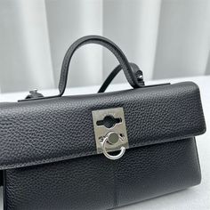 a black purse with a metal lock on it