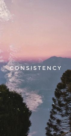 the words constistency are in front of some trees and mountains at sunset