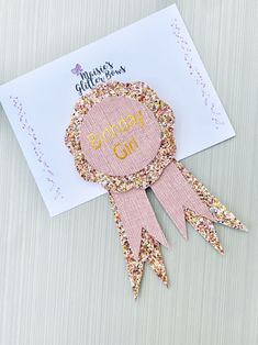 a pink and gold award ribbon on top of a white card with the words congratulations girl