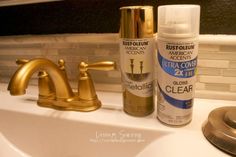 a bathroom sink with gold faucet next to it's spray bottle and soap dispenser