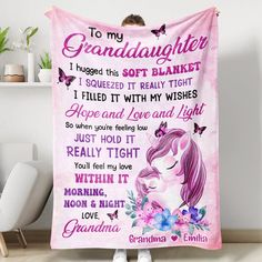 a girl is holding a pink blanket with the words to her granddaughter and butterflies on it