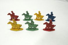 small toy figurines of horses and jockeys sitting on top of each other