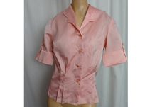 "Shimmery pink 1950s ladies shirt. - pink medium weight shimmery fabric (rayon faille) - short sleeves with wide turned up cuffs with tab and button - pearly buttons at the front  - buttonhole in the pointed collar - unique shaped collar - fitting seams and darts - straight bottom designed to be tucked in - seams finished with pinking - label - none - condition - Excellent and clean. Sturdy and almost appears unworn. One tiny pin hole in the back.  39\" bust  30\" waist  15\" shoulder seam to sh Pink Fitted Short Sleeve Shirt, Pink Short Sleeve Blouse For Formal Occasions, Fitted 1950s Style Short Sleeve Tops, 1950s Style Fitted Short Sleeve Tops, Fitted Short Sleeve Tops In 1950s Style, Fitted Retro Pink Blouse, Fitted Vintage Pink Blouse, Vintage Pink Collared Shirt, Classic Short Sleeve Party Blouse