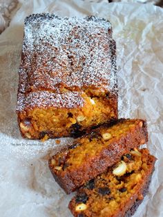 two pieces of cake sitting on top of some white wax paper with powdered sugar