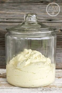 a jar filled with whipped cream sitting on top of a wooden table