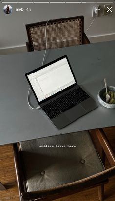 an open laptop computer sitting on top of a wooden table