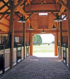 the inside of a horse barn with stalls and lights