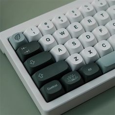 a computer keyboard with white keys and green letters on the keycaps is shown